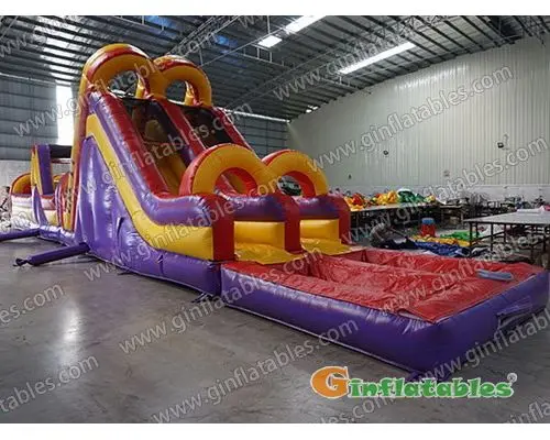 Purple dual lane obstacle course with pool